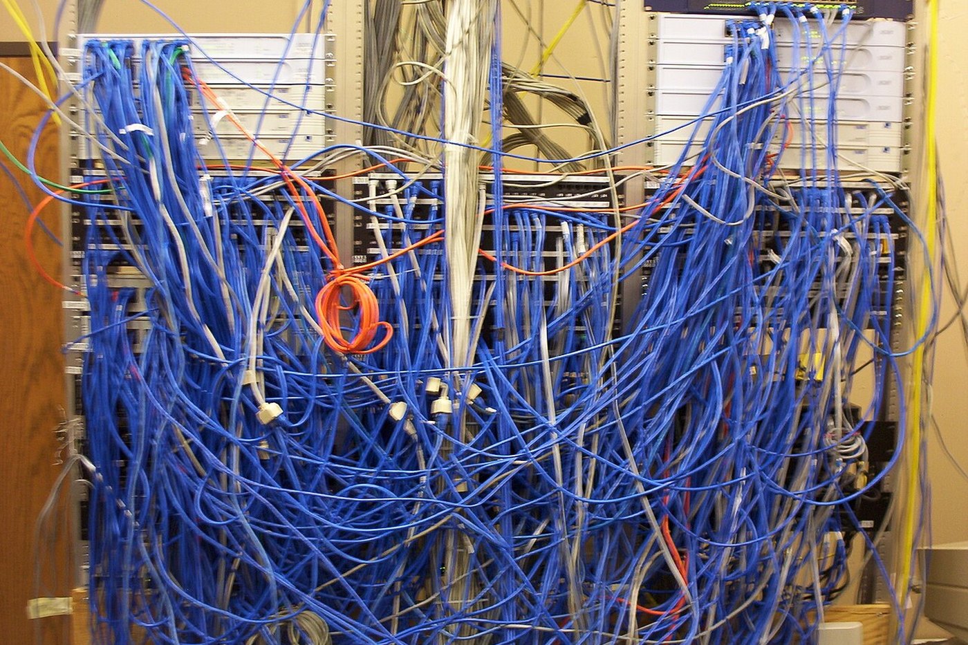 A structured cabling closet with dense bundles of patch cables terminating at panels